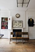 White wooden panelling in a living room - a studio with an old wooden bench in front of a fireplace and a built-in cupboard