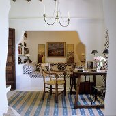 A chair and a desk on a striped rug in front of a Mediterranean-style alcove