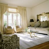 Upholstered sofas and glass table with antique brass frame in a bright living room