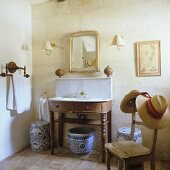 Ceramic jars under a simple washstand in a rustic house