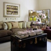 An old leather trunk in front of a brown sofa with cushions