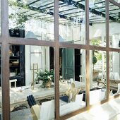 A view through a metal transom window onto an extension with a dining table