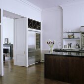 An open-plan kitchen in a period building with open swing doors