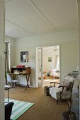 A comfortable armchair and a study corner next to an open sliding door with a view into a living room