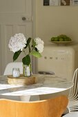 White flowers in a vase on a dining table with marble tabletop