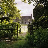 Blick vom verwilderten Garten auf altes Bauernhaus
