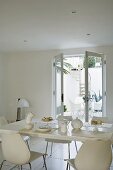 Breakfast in a white dining room with a view through an open terrace door