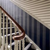 A wooden stairway with a striped pattern on the wall