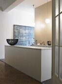 Offene Küche im minimalistischen Vorraum - weiße monolithische Küchentheke mit Korb