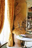 Tongefäss mit spiralförmiger Dekopflanze und gelber Vorhang in Wohnzimmerecke