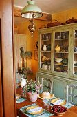Essen im Landhaus - Küchenbuffet mit Geschirr und antike Deckenlampe