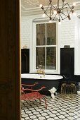 A bathroom with furniture in a mixture of styles on black and white tiles