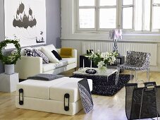 White living room suite with patterned chair and modern coffee table in front of a bank of windows