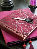 Photo album with red flora pattern and scissors