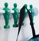 Black shoulder strap on a wardrobe rod with green men