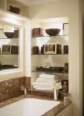 Traditionelles Bad mit Marmorverkleidung an Badewanne und Glasböden in Nische
