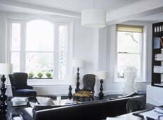Black and white sitting room with leather sofa facing two chairs