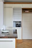 Central island unit with granite worktop in contemporary kitchen