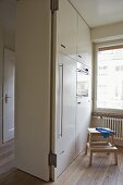 Moderne Küche mit weißem Einbauschrank und Einbaugerät neben offener Tür