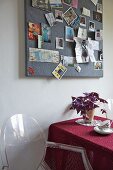 Louis Ghost chair next to table beneath pinboard