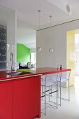 Sofa bottles on red worktop in modern kitchen