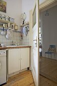 Corner of modern kitchen with view through open door to hallway