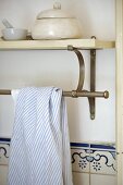 Tea towel over steel bar fixed below shelf