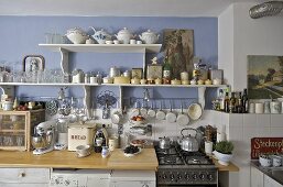 Kitchenware and tableware on shelves above kitchen worktop