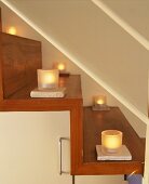 Burning tea lights on a wooden staircase