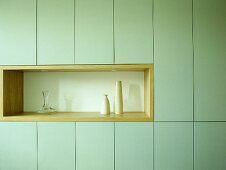 Light green units with glass vase and pottery vases in recess