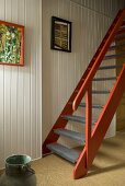 Red-brown wooden stairs in front of a white wood wall