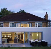 A modern extension in front of a villa with a brick facade