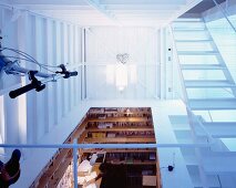 A gallery with stairs and a view of a study corner in front of an open-plan living room