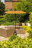 Wicker furniture on a terrace under a yellow sunshade