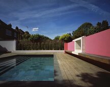 Moderne Architektur - Pinkfarbene Wand mit Holzbank vor Pool