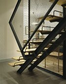 Offenes Treppenhaus mit Metalltreppe und Geländer aus Maschendraht