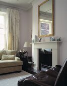 A brown leather armchair and a white sofa in front of a fireplace with a mirror above it