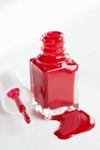 Red nail varnish, an open bottle and a brush