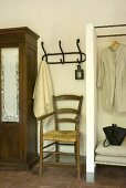 A chair, coat hooks and a clothes rail in a hallway