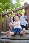 Junge Familie mit Tochter auf einem Spielplatz