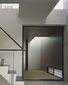 Zeitgenössisches Treppenhaus mit Blick in leeren Raum und Tatamimatte auf Boden