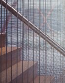 Contemporary staircase with see-through metal grid dividing the staircase from the rest of the room