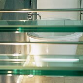 A bathtub behind glass stairs