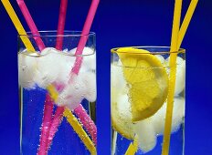 Two glasses of cold mineral water with coloured straws