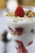 Layered dessert of yoghurt, muesli & raspberries (close-up)