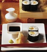 Maki-Sushi mit Sojasauce und eingelegtem Ingwer