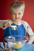 Small boy making a cake