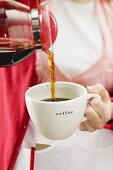 Waitress pouring coffee into a cup