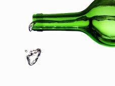 Wasser spritzt aus grüner Flasche