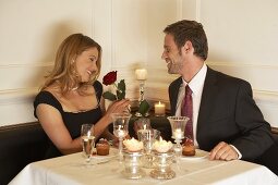 Young woman accepting rose at dinner in a restaurant